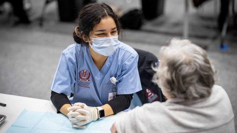 A Loma Linda University School of Nursing student chats with a community member about what to expect from the COVID-19 vaccine.