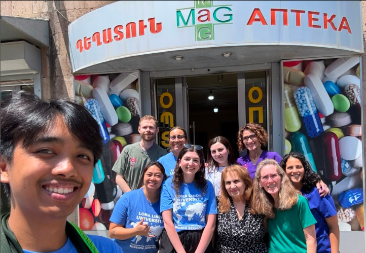 Third-year PharmD student LouBlayne Dilag, along with some of his pharmacy school friends and faculty standing outside a health clinic in Armenia