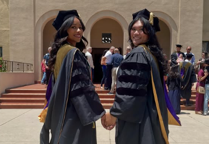 Class of 2026 School of Pharmacy two graduates looking over shoulder