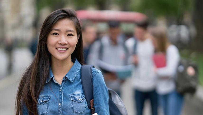 student smiling holding a book