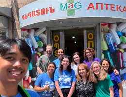 Third-year PharmD student LouBlayne Dilag, along with some of his pharmacy school friends and faculty standing outside a health clinic in Armenia