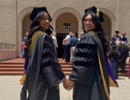 Class of 2026 School of Pharmacy two graduates looking over shoulder