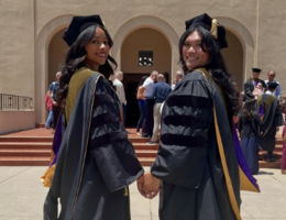 Class of 2026 School of Pharmacy two graduates looking over shoulder