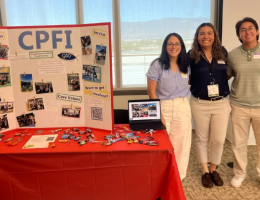 Pharmacy students at student organization fair standing next to mission trip booth